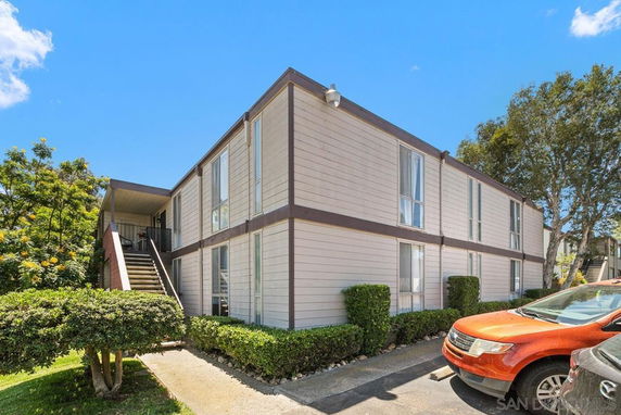 Front view of a two-story residential building with an external staircase.