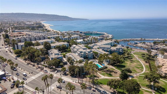 Aerial view of a coastal area with residential buildings near a marina and beach.