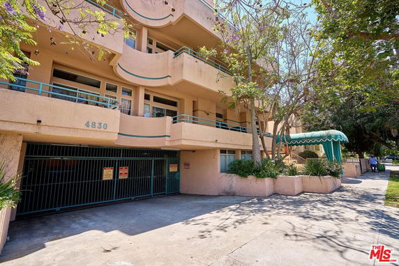 Front view of a multi-story building with balconies and decorative awnings.