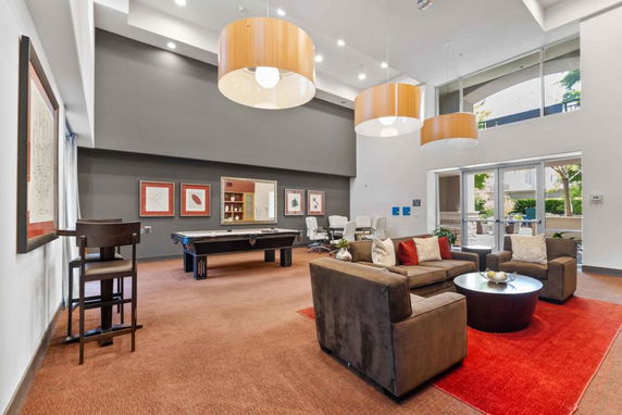 Interior view of a clubhouse with seating area and pool table.