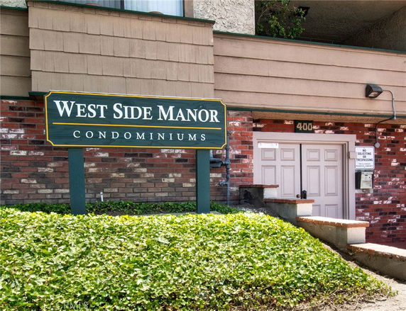 Front view of West Side Manor Condominiums showing the entrance and building facade.