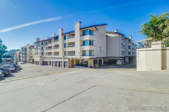 Front view of a multi-story apartment building with garages.