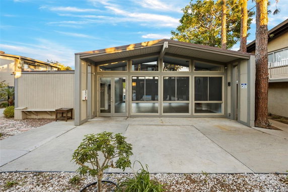 Front view of a building with a glass entrance and sloped roof.