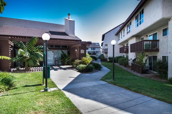 Front view of residential buildings with balconies and a walkway.