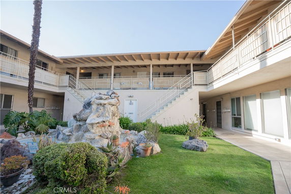 Front view of a multi-level building with exterior staircases and railing.