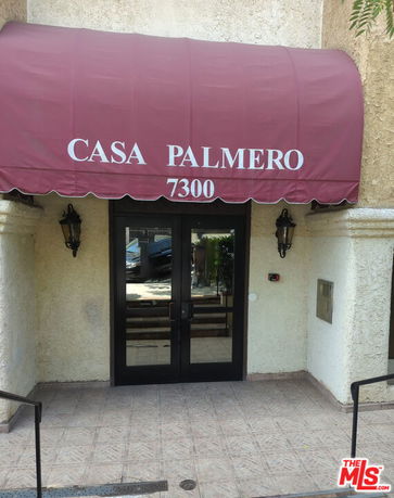 Entrance of a building with a red canopy labeled 'Casa Palmero' and door number 7300.