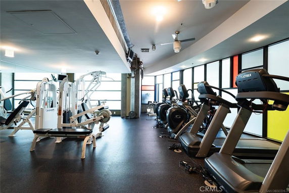 Interior view of a gym with exercise equipment and treadmills lined up.