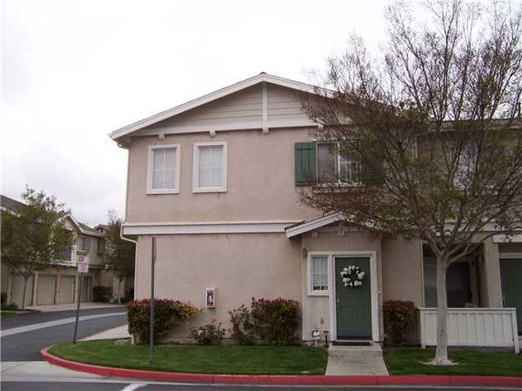 Front view of a two-story residential building with a green door.
