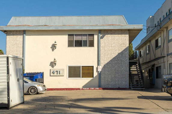 Front view of a two-story building with a staircase on the side.