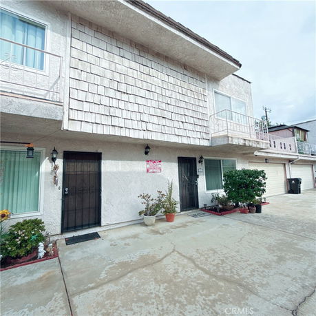 Front view of a multi-story building with balconies and double garage doors.