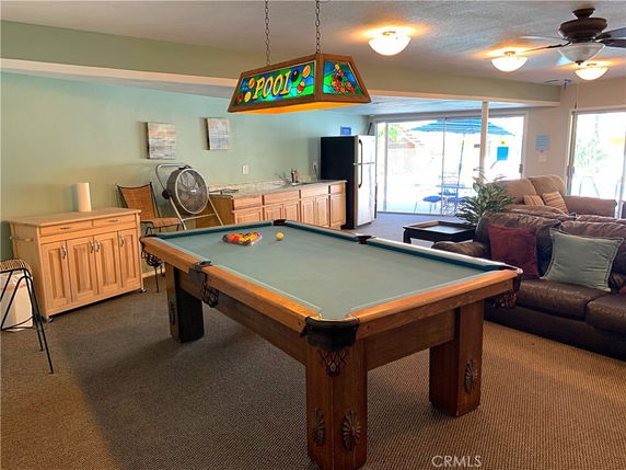 Interior of a recreation room with a pool table and seating area.