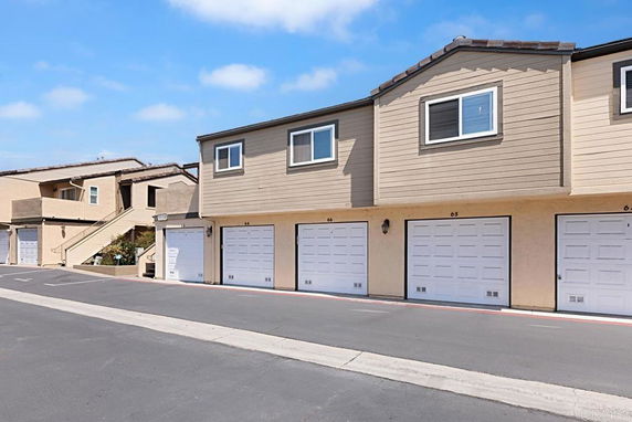 Front view of a multi-story building with a series of garages on the ground level.