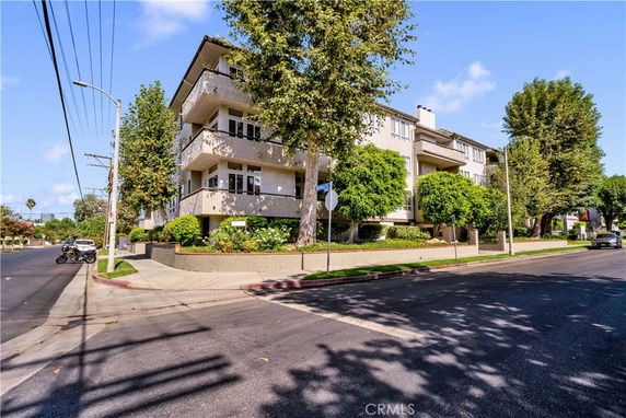 Front view of a multi-story apartment building on a street corner.