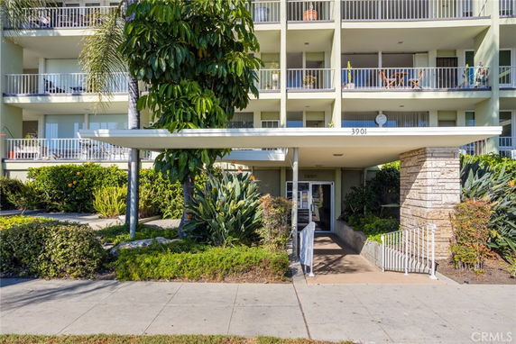 Front view of a multi-story apartment building with balconies.