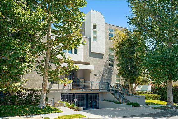 Front view of a modern multi-story residential building with a stairway entrance.