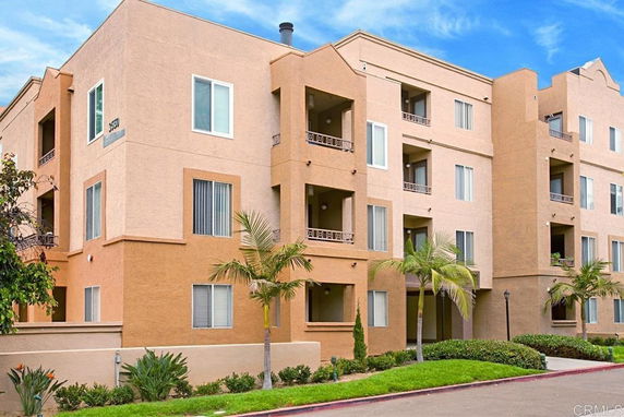 Front view of a multi-story apartment building with a beige facade.
