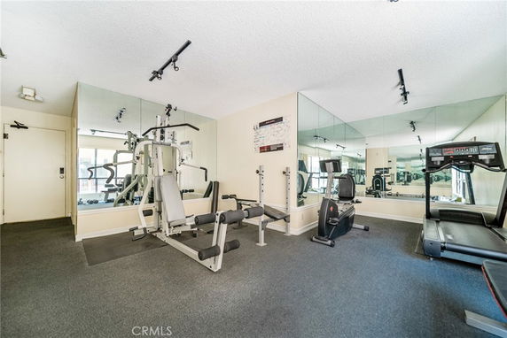Indoor gym area with exercise equipment including a treadmill and weight machine.