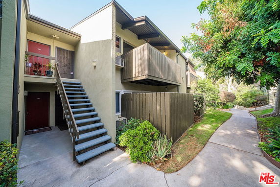 Front view of a two-story apartment building with exterior stairs and balconies.