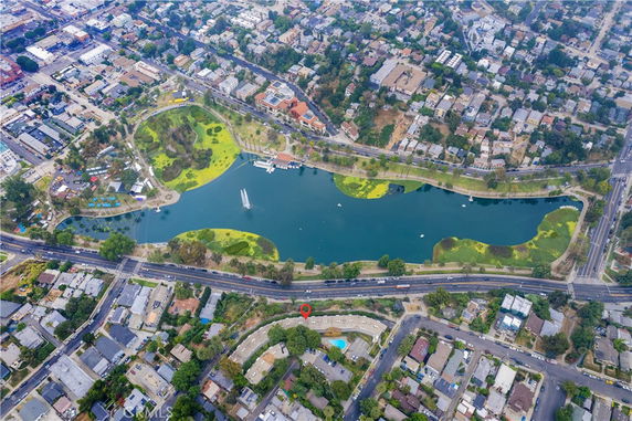 Aerial view of a cityscape with a large lake surrounded by buildings and roads.
