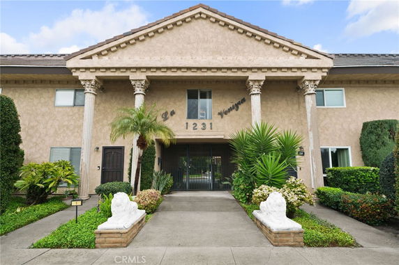 Front view of a two-story building with decorative columns and a central entrance.