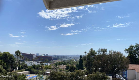 Panoramic view of cityscape with buildings and trees against a clear sky.