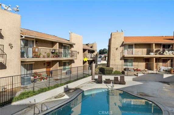 View of apartment buildings surrounding a swimming pool area.