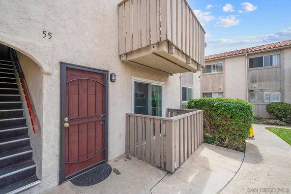 Front view of an apartment entrance with a small balcony above.