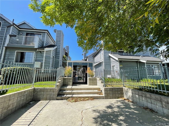 Front view of a multi-story residential building with a gated entrance.