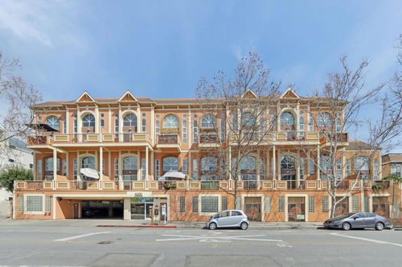 Front view of a multi-story residential building with decorative architectural features and balconies.