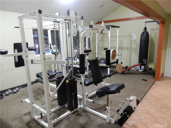 Indoor gym area with various exercise equipment including weight machines and a punching bag.