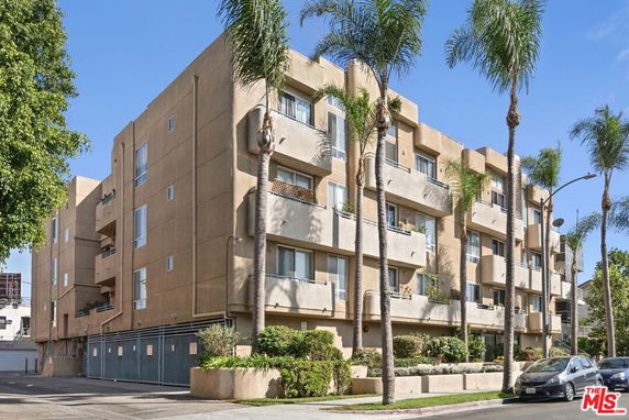Front view of a multi-story apartment building with balconies.