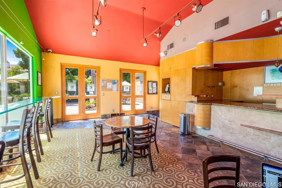 Interior view of a club house with colorful walls, seating area, and counter.