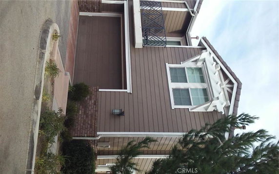Front view of a two-story house with a garage and balcony.