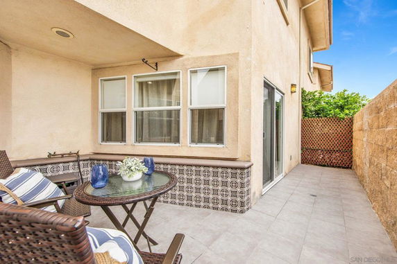 Front view of a multi-story house with a tiled patio area.