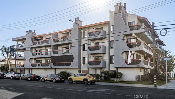 Front view of a multi-story apartment building with balconies.
