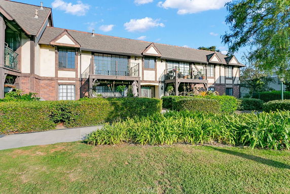 Front view of a two-story house with Tudor-style architecture and a well-maintained garden.