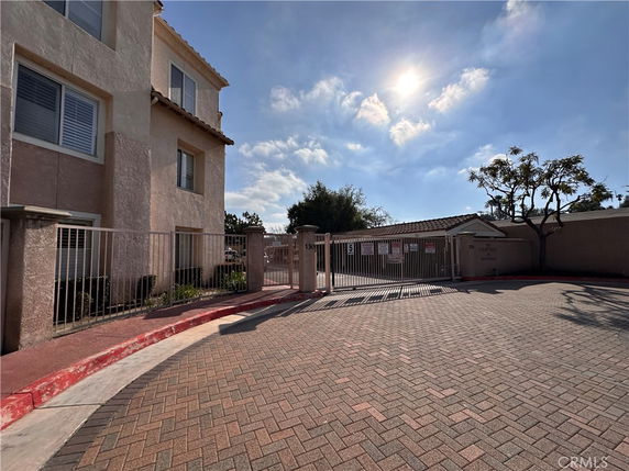 Front view of a multi-story residential building with gated entrance.