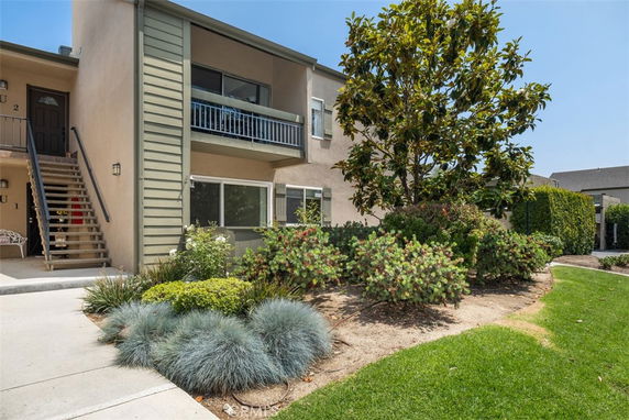 Front view of a two-story apartment building with a staircase leading to the upper level.