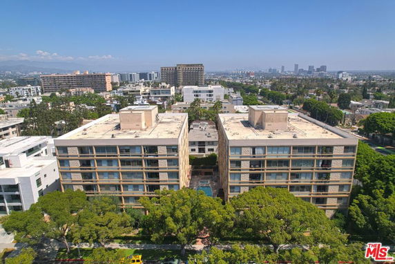 Aerial view of two large apartment buildings with surrounding cityscape.