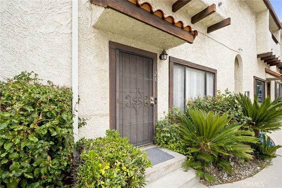 Front view of a house with a metal door and small porch.