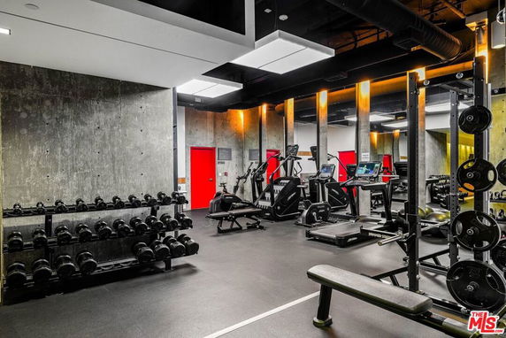 Interior view of a gym area with fitness equipment and weights.