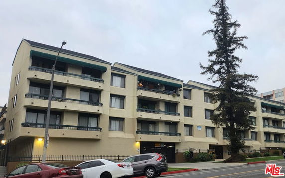 Front view of a multi-story apartment building with balconies.