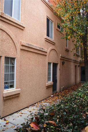 Front view of a two-story building with textured walls and several windows.