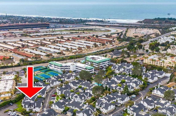 Aerial view of residential area near a racetrack and ocean.