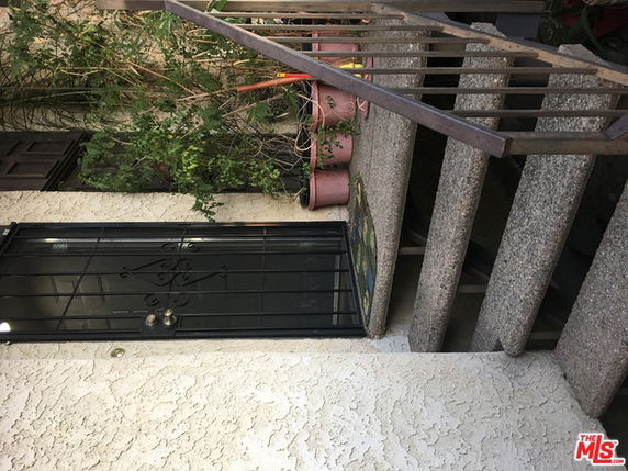 Front view of a building entry with stairs and railing.
