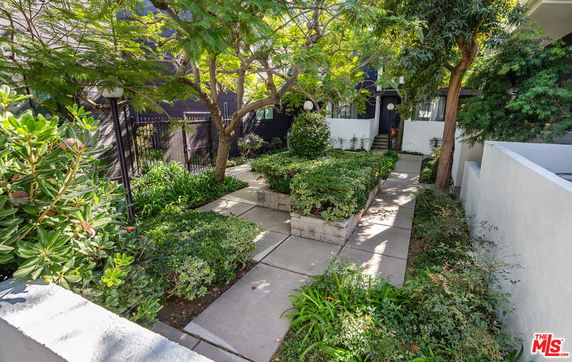 Front view of a house with a landscaped garden and pathway leading to the entrance.