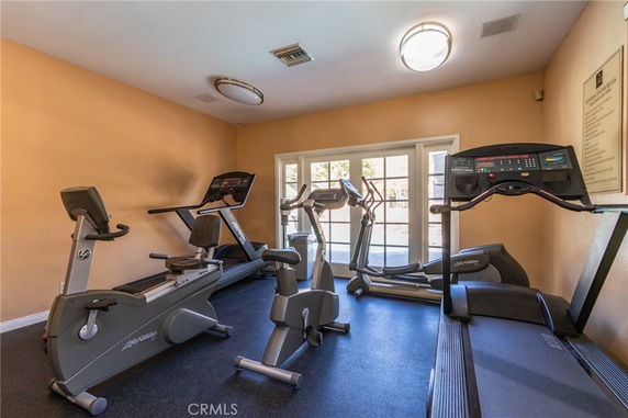 Indoor gym area with fitness equipment including treadmills and stationary bikes.
