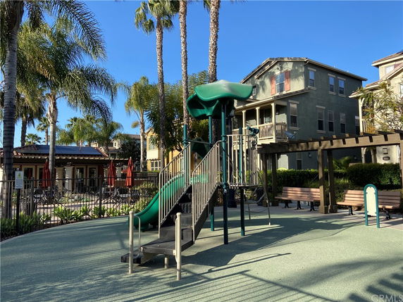Outdoor recreational area with children's play structure and nearby benches.