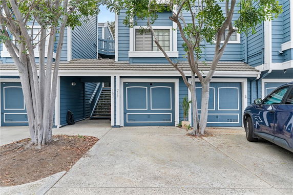 Front view of a two-story house with blue siding and a garage.