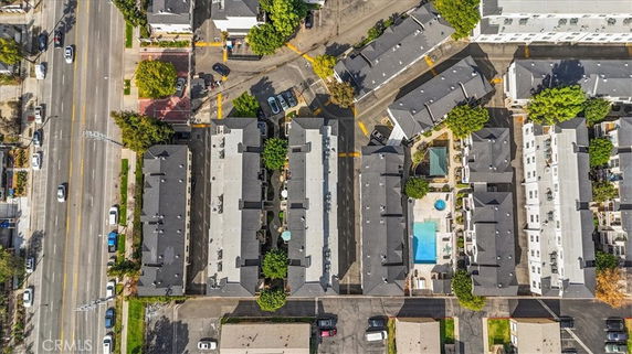 Aerial view of multiple residential buildings with parking and a swimming pool.